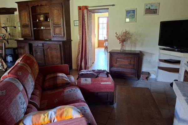 Salon convivial avec tv connectée, charme authentique avec pierres du périgord et oeil de boeuf apparant