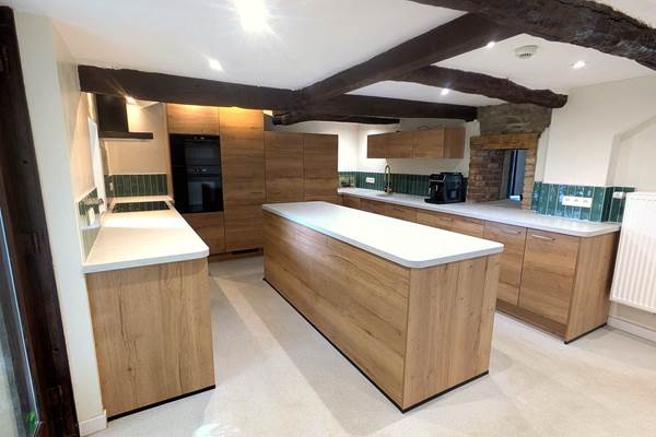 Bright open-plan kitchen connected to dining and living area in group accommodation