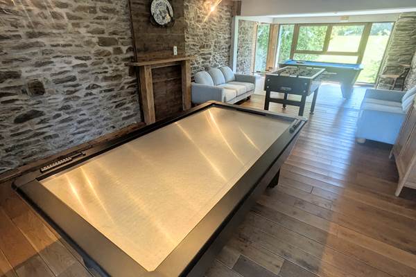 alt="Jeu de air hockey et fléchettes dans la salle de jeux du gîte familial en Belgique"