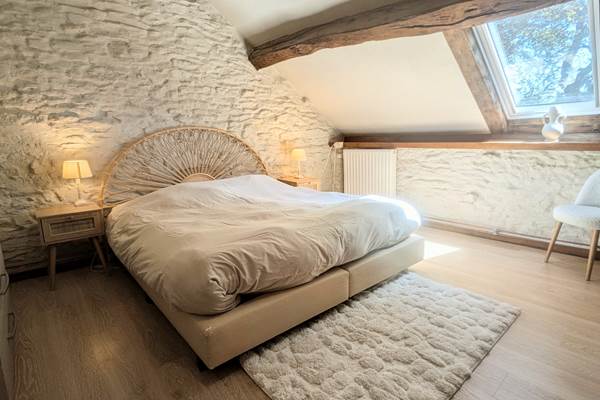 alt="Chambre spacieuse avec lit king size dans le gîte familial avec piscine en Belgique"