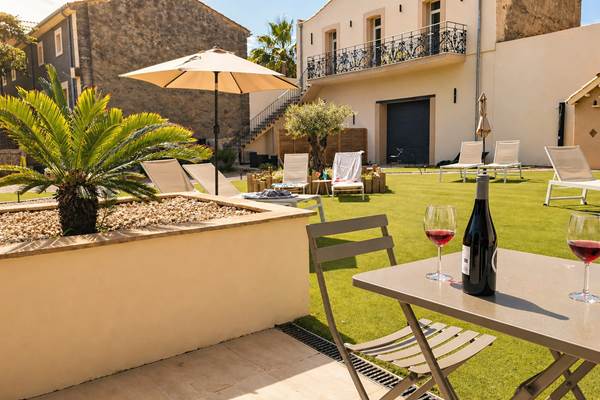 Terrasse ensoleillée aux Gîtes de Monte Blanco avec table dressée et espace détente au printemps dans l’Hérault
