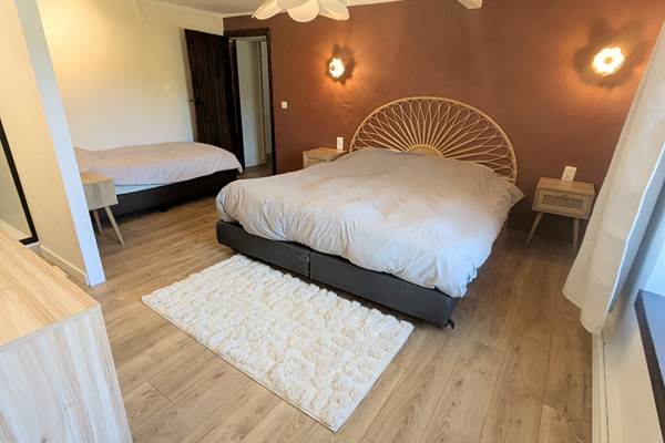 alt="Chambre spacieuse pour famille avec lit king size, couchage simple et douche privée en Ardenne belge"