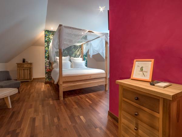 <img src="chemin-de-l-image.jpg" alt="Grande suite Grenade avec lit confortable et vue sur le jardin tropical à l'hôtel de charme La Maison de Clémentine, Fort-de-France, Martinique"