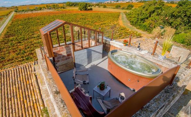Jacuzzi avec vue panoramique sur les vignes dans une chambre romantique en Occitanie