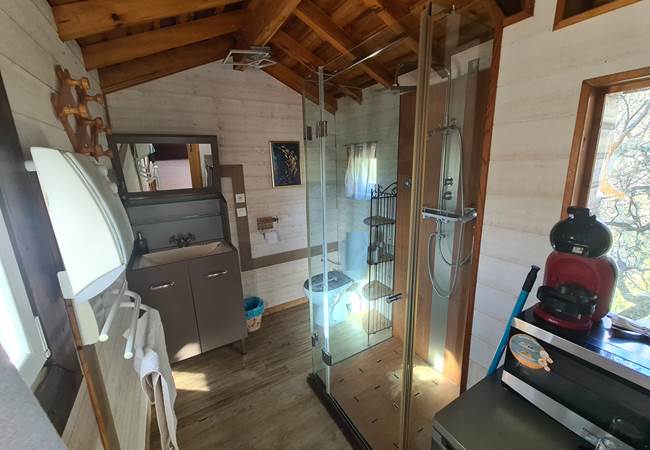 Une jolie salle de bain avec douche, WC, lavabo, et frigo cafetière, bouilloire