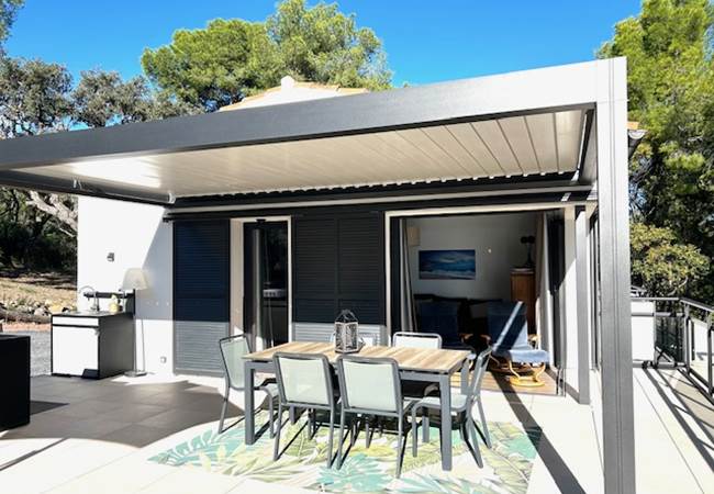 Espace repas extérieur protégé par une pergola bio-climatique