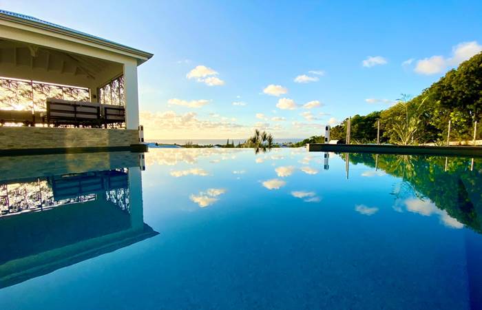 Piscine à débordement vue mer avec coin salon sous le carbet