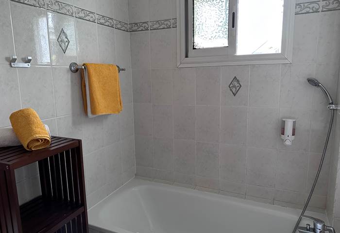 salle de bain privée avec baignoire, toilette et vasque.