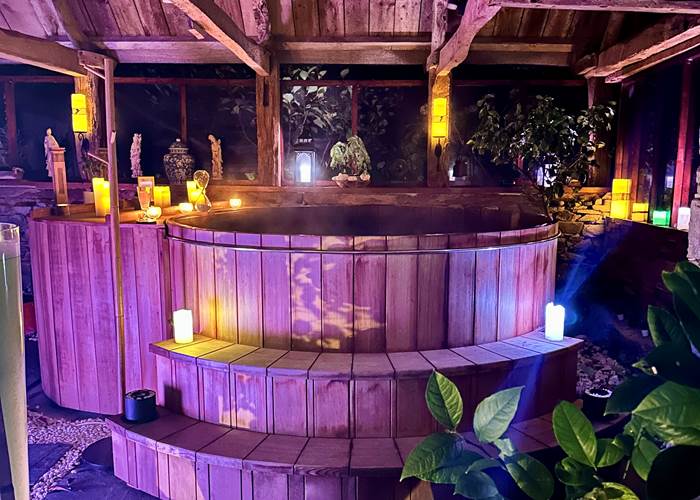 se délasser dans l'eau chaude du bain Ofuro dans une atmosphère tamisée avec bougies, musique relaxante et huiles essentielles (expérience sensorielle unique)
