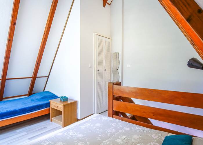 Le grand lit et le lit 1 personne dans la chambre mezzanine à l'étage