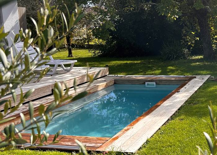 La piscine de Maison Ginette dans un environnement fleuri