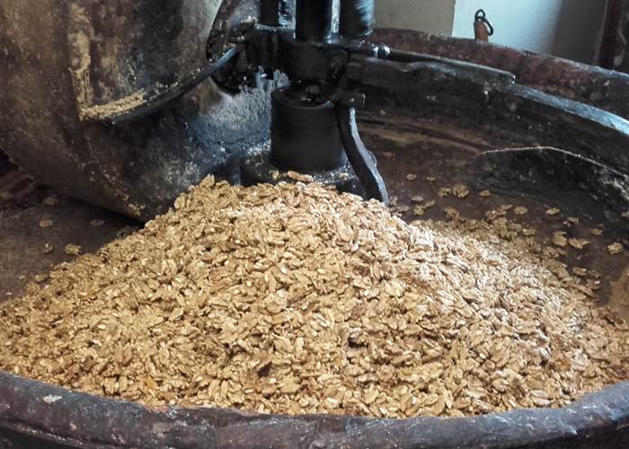 Broyage des cerneaux à la meule de pierre