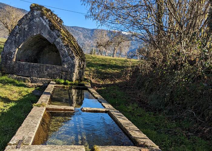 Découvrez le lavoir médiéval de Poisieu, un vestige authentique dans le Bugey. Ce lavoir offre une vue imprenable sur le  Grand Colombier. Un lieu paisible où nature et patrimoine se rencontrent.