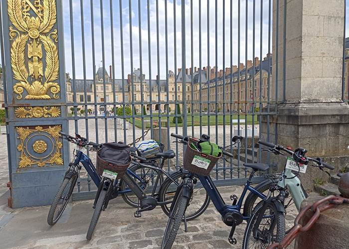 Pause devant le Chateau de Fontainebleau en vélo électrique avec Stations bees Melun Location de vélo