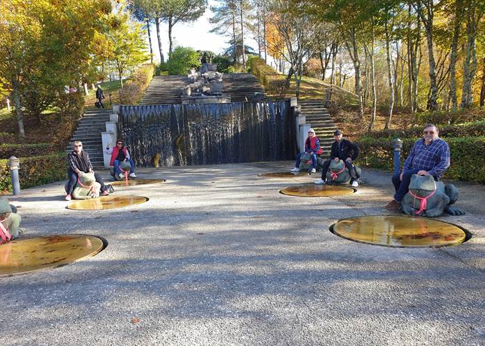 Groupe d'amis heureux sur la fontaine monumentale du parc public