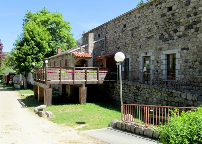 Vue sur la terrasse côté camping et sur l'entée des sanitaires
