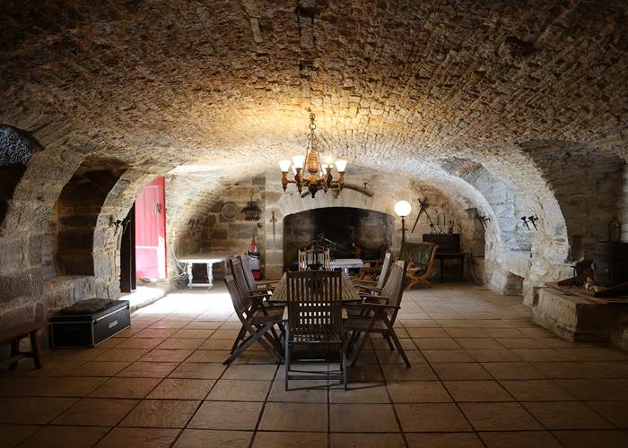Grande salle voûtée en pierre au Château de Saint-Chamarand, espace de réception dans le Lot