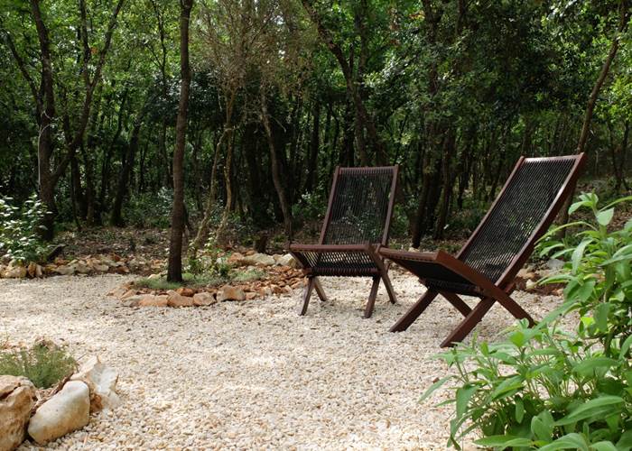 La terrasse de l'Ecogîte à l'ombre des chênes