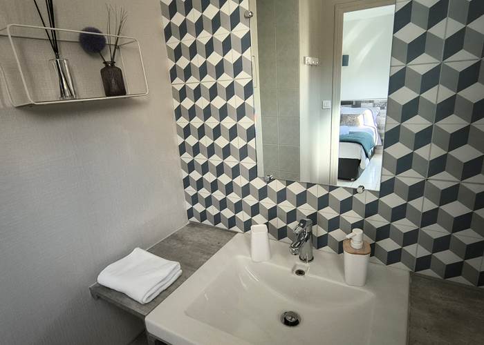 Salle d'eau équipée avec douche et lavabo dans la chambre d'hôtes familiale