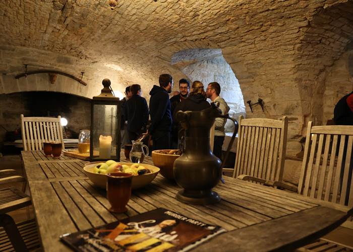 Retrouvaille entre amis dans la salle voutée pour jouer la murder party Louis XIII au Château de Saint-Chamarand