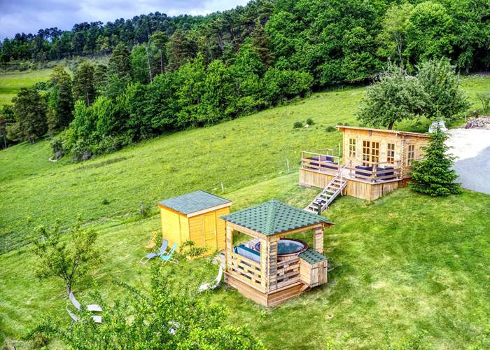 Espace balnéo composé d'un bain extérieur à bulles et jets hydromassants 6/8 pers, d'un sana infrarouge 6/8 pers. et d'un chalet cocooning