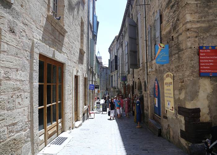 Ruelle du centre historique de Pézenas avec façades en pierre et ambiance paisible au printemps