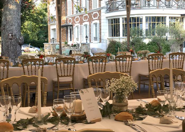 Repas de mariage de mariage sur la terrasse en bois couverte d'un chapiteau