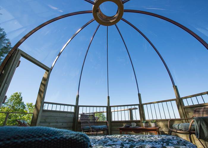 Intérieur du dôme Domostella avec lit double et vue directe sur le ciel étoilé à Noailhac
