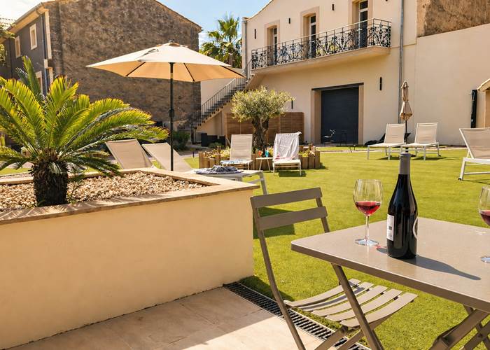 Terrasse ensoleillée aux Gîtes de Monte Blanco avec table dressée et espace détente au printemps dans l’Hérault