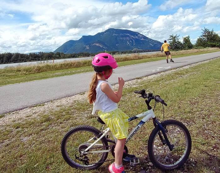 Cycliste sur la Via Rhôna, avec le Grand Colombier en arrière-plan. Paysage emblématique du Bugey (Auvergne-Rhône-Alpes)