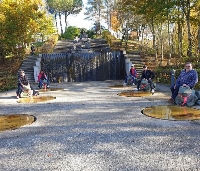 Groupe d'amis heureux sur la fontaine monumentale du parc public