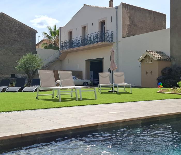 Piscine du gîte Le Ramonetage aux Gîtes de Monte Blanco à Montblanc, avec transats et parasols en été