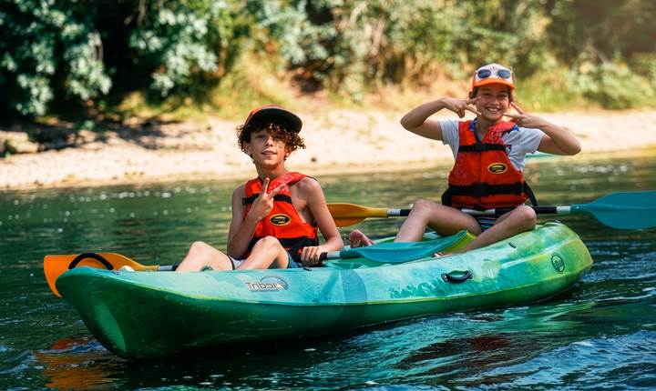 Les enfants profitent d’une balade en kayak sur l’Aveyron dans une ambiance ludique et familiale au cœur d’une nature préservée.
