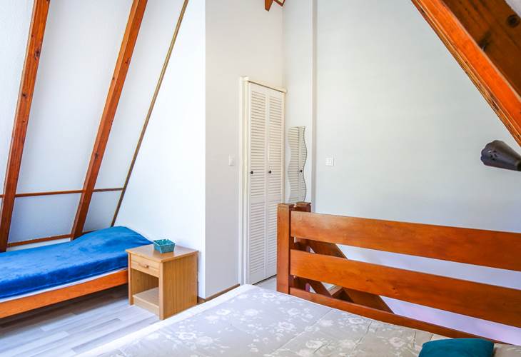 Le grand lit et le lit 1 personne dans la chambre mezzanine à l'étage
