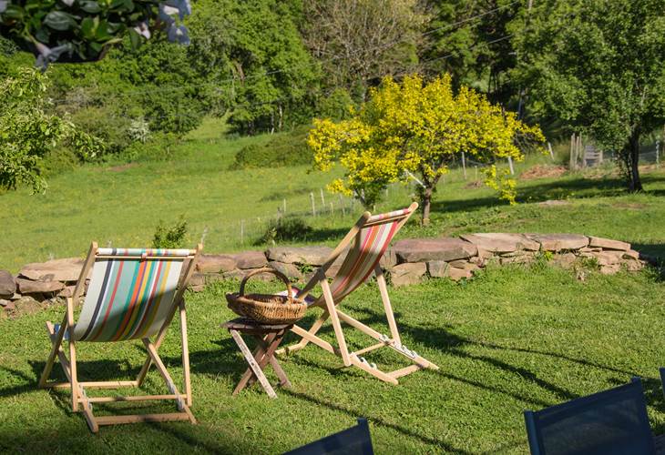 Jardin du gîte Grande Ourse à Noailhac avec chaises longues et vue panoramique sur la campagne