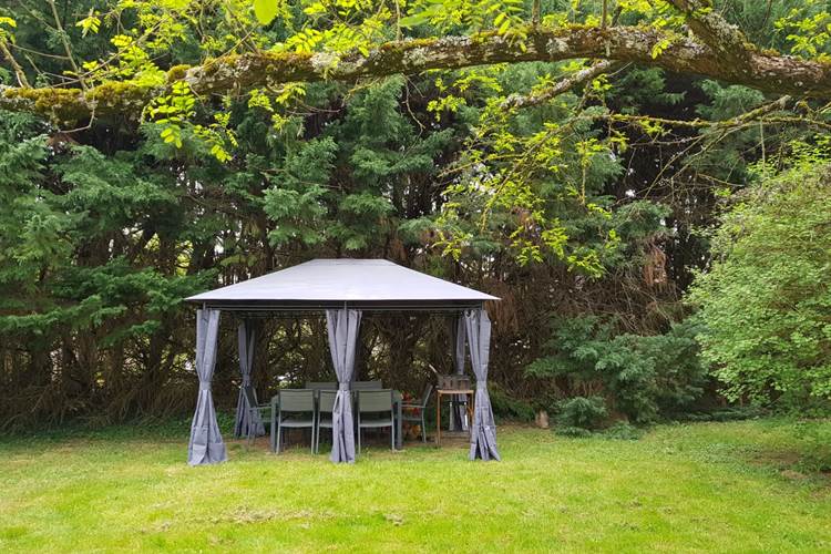 Pergola dans le jardin avec table pour 8 et BBQ