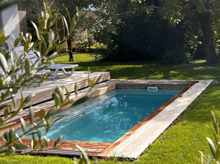 La piscine de Maison Ginette dans un environnement fleuri