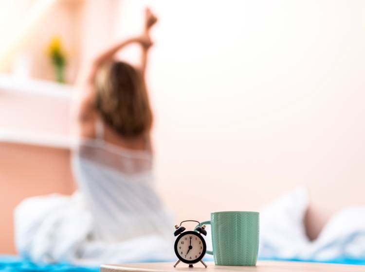 close-up-cup-clock-with-stretching-woman-background