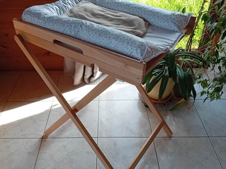 Une table à langer en bois de hêtre, pliable, pratique avec son matelas à langer.