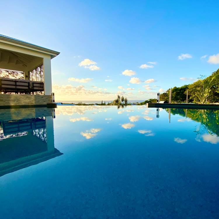 Piscine à débordement vue mer avec coin salon sous le carbet