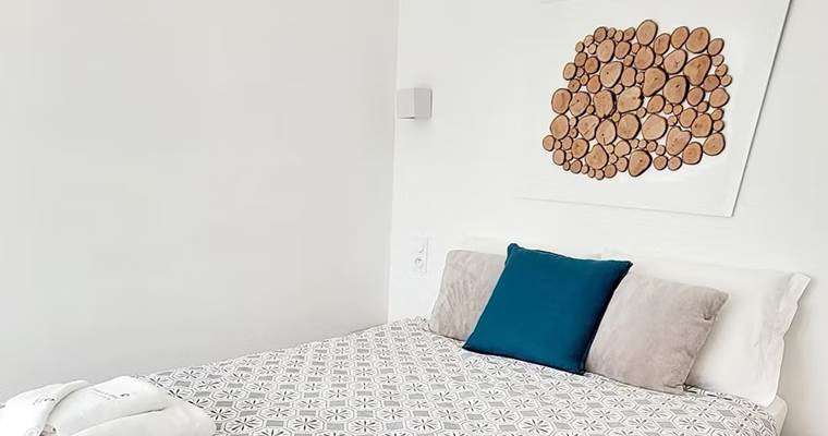 Petite chambre d'hôtes confortable et cosy avec décoration murale en bois naturel.