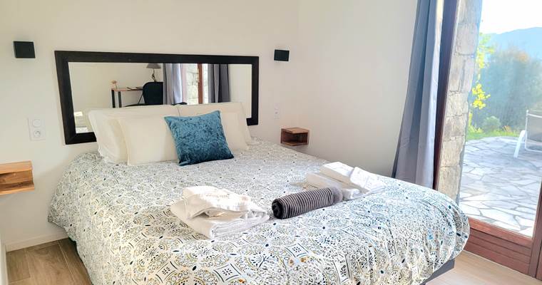 Chambre d'hôtes n°4 lumineuse avec lit queen size et accès direct à une terrasse privée.