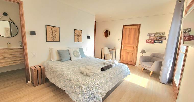 Chambre d'amis 1 spacieuse avec lit double, décoration naturelle et ambiance lumineuse au Domaine Cardu.