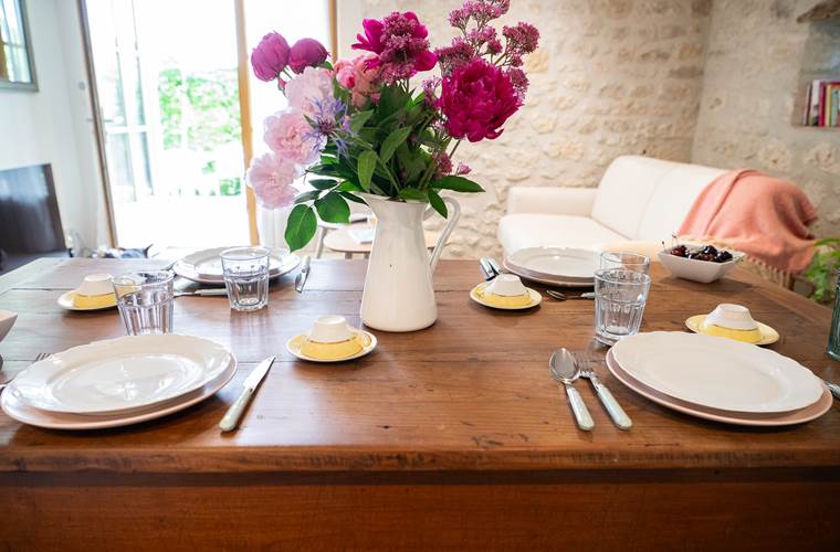 Table dressée avec fleurs dans la pièce de vie