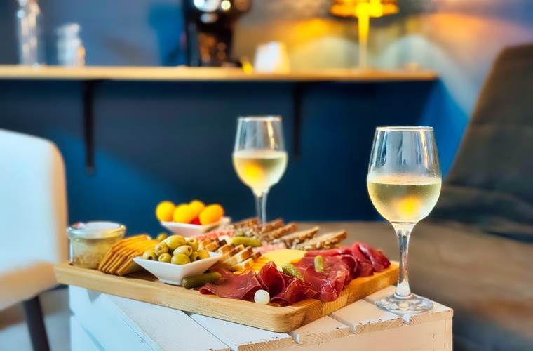 Planche apéritive et verres de champagne servis dans l’espace spa privatif Le Magnolia