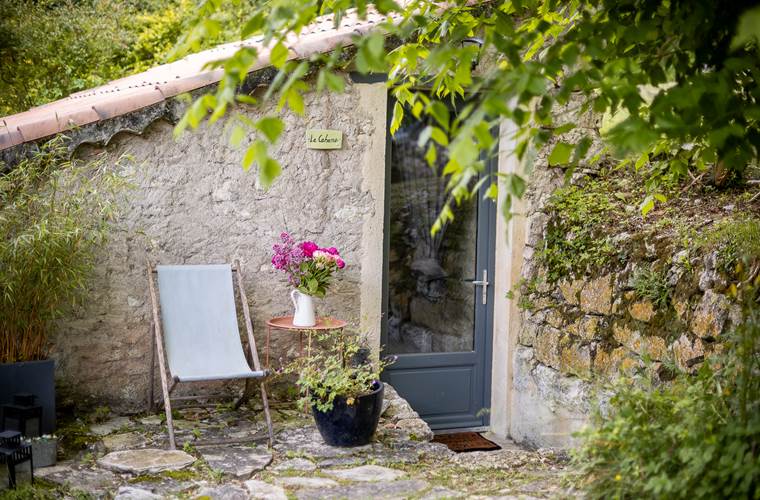 Façade en pierre de la Cabane avec coin détente extérieur