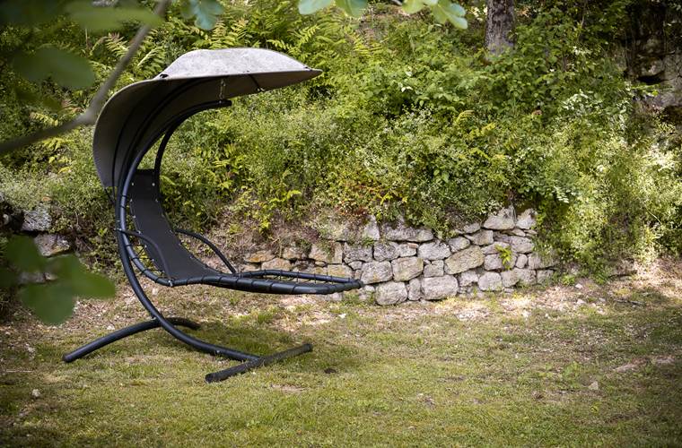 Espace détente avec hamac et fauteuil suspendu sous les arbres