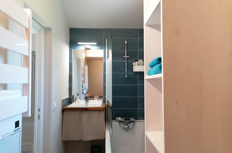 salle de bain avec baignoire, lavabo et WC. Elle est équipée d'un radiateur sèche-serviette. Le gel douche et les serviettes sont fournis.