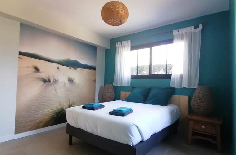 Dune: chambre à la décoration soignée propose des rangements  pour vos affaires