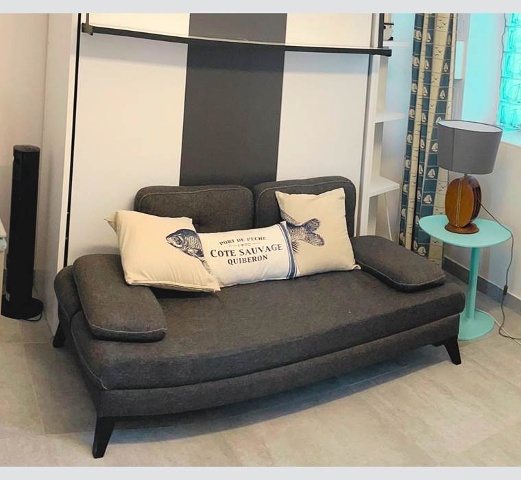 Studio – Coin salon avec charme rétais Ambiance chaleureuse et touche marine dans cet espace modulable en plein centre piéton. Confort assuré pour un séjour paisible à La Flotte